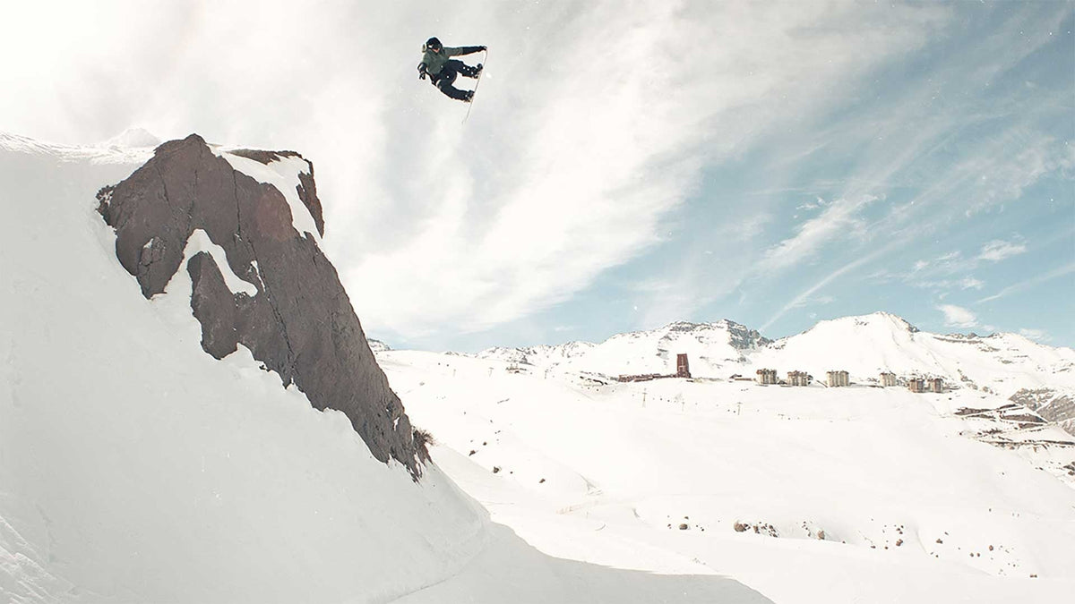 Snow boarder jumping off a cliff
