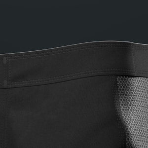 Close-up of a black garment with mesh lining on a dark background