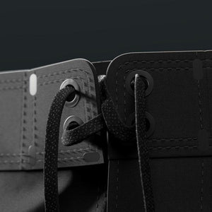 Close-up of a black leather belt with a buckle on a dark background