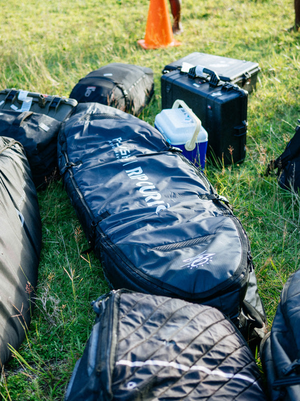 Black bags with visible branding on a grassy ground