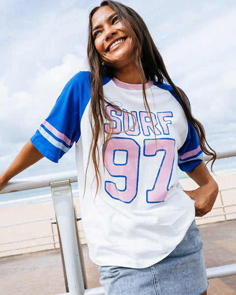 Woman wearing a 'Surf 97' t-shirt by the beach