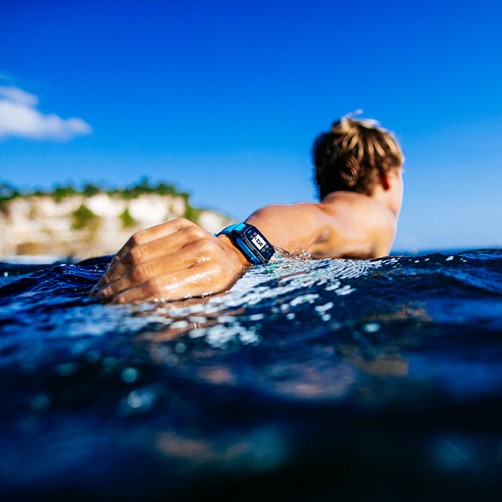 Person surfing with a clear blue sky and ocean background