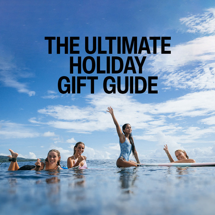 People in the water with a clear blue sky and 'The Ultimate Holiday Gift Guide' text.