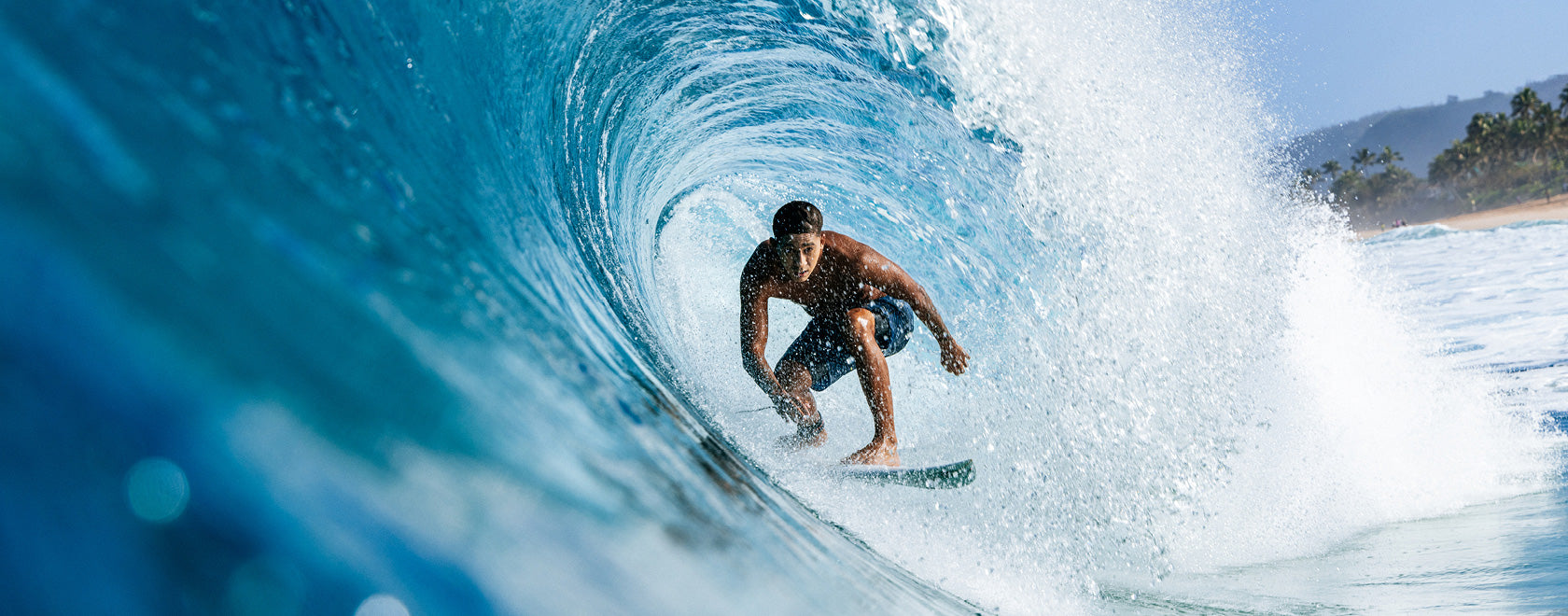 Person surfing on a wave with a clear blue sky