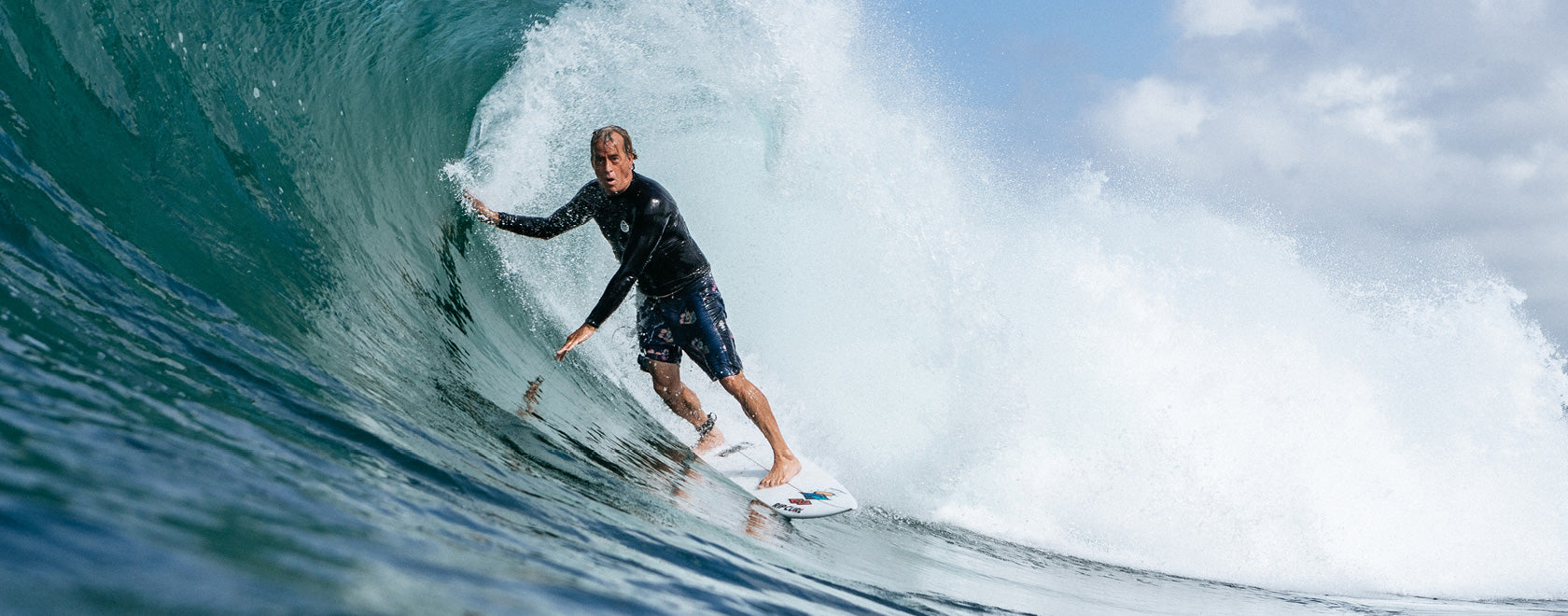 Person surfing on a wave with a clear sky in the background